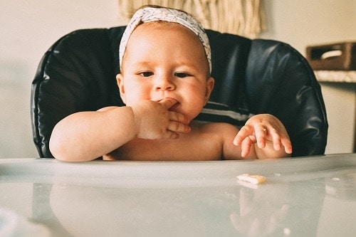 Baby sitting in black highchair