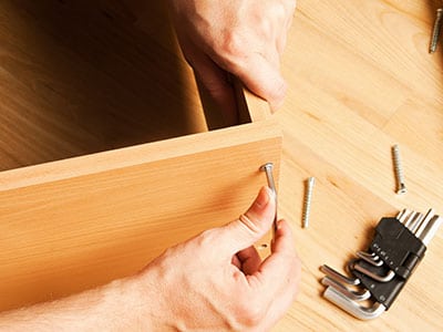 two hands assembling a baby crib - best cribs