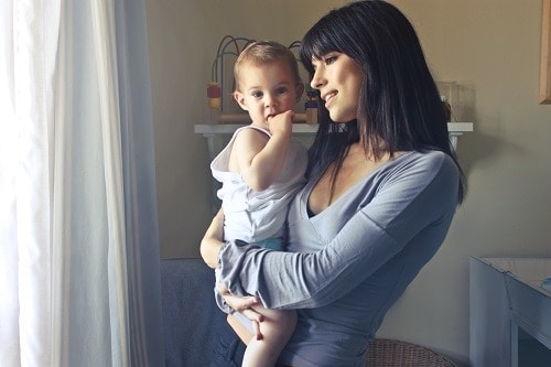 woman carrying baby boy wearing white shirt
