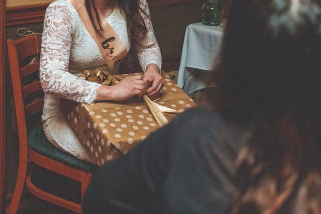 Woman sitting and opening her gift