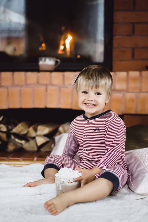baby smiling near fireplace