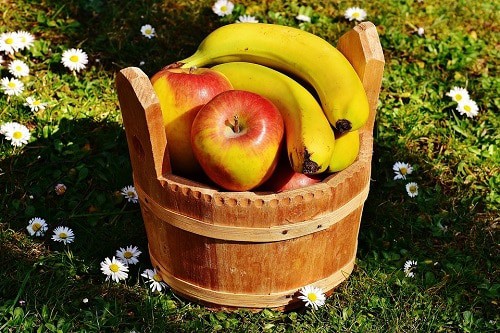Banana and apple on th basket wood