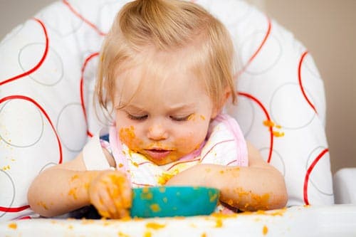 baby making a mess in a high chair