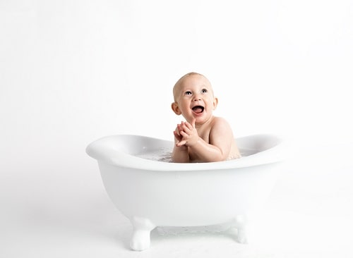 baby inside white bathtub