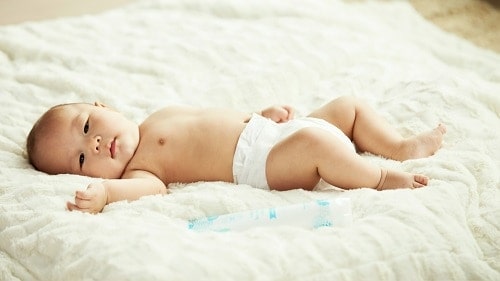 baby in a diaper on the bed