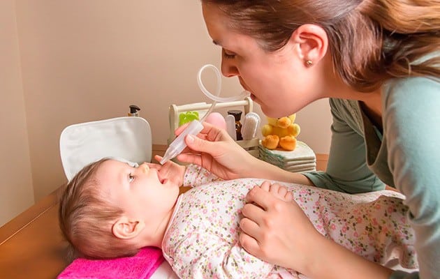 mother using a nasa aspirator to suck snot foamier baby's nose