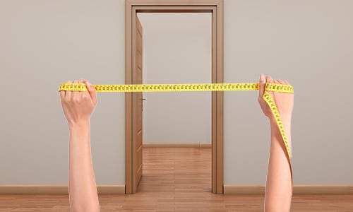 measuring up a doorway with a tape measure to fit a baby gate