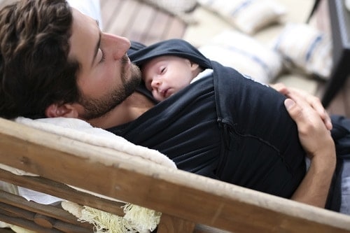 Man lying and baby wrap