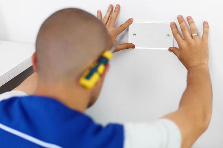 Man installing blank plate over coaxial outlet