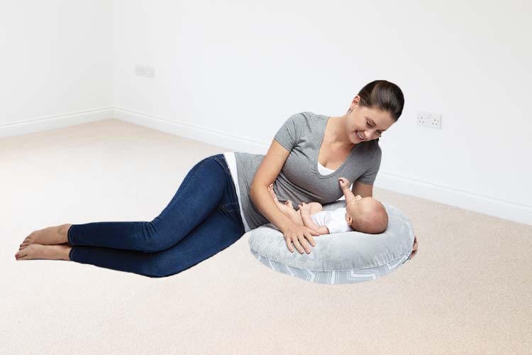 Woman playing with baby in infant lounger