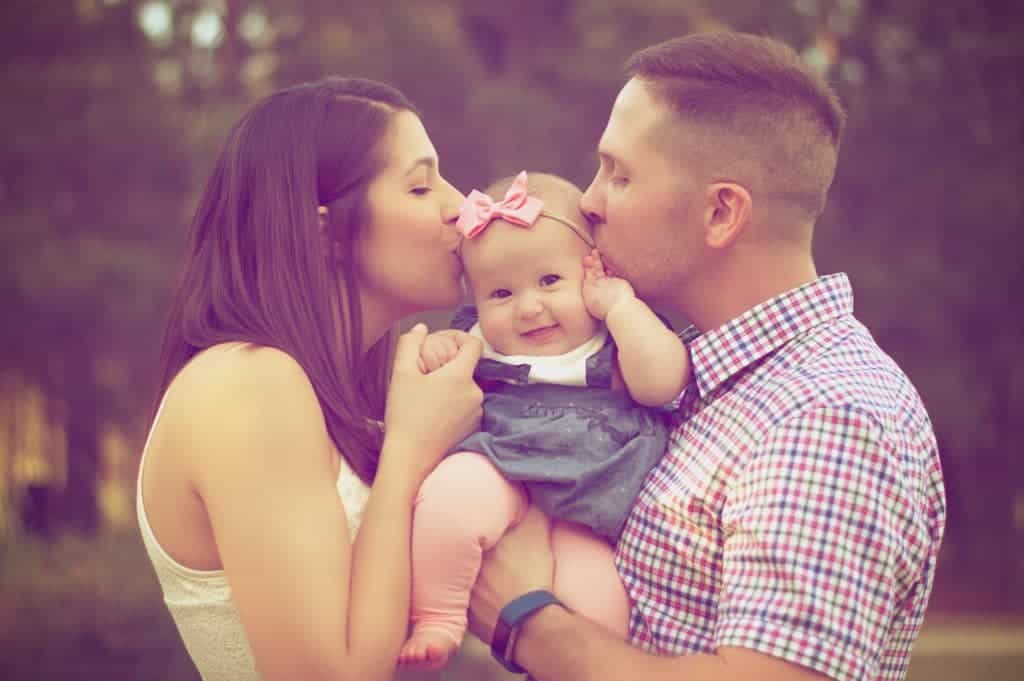 couple kissing their child