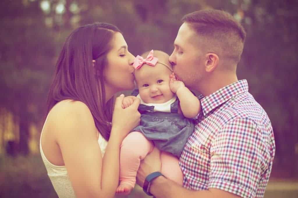 Couple kissing baby while carrying