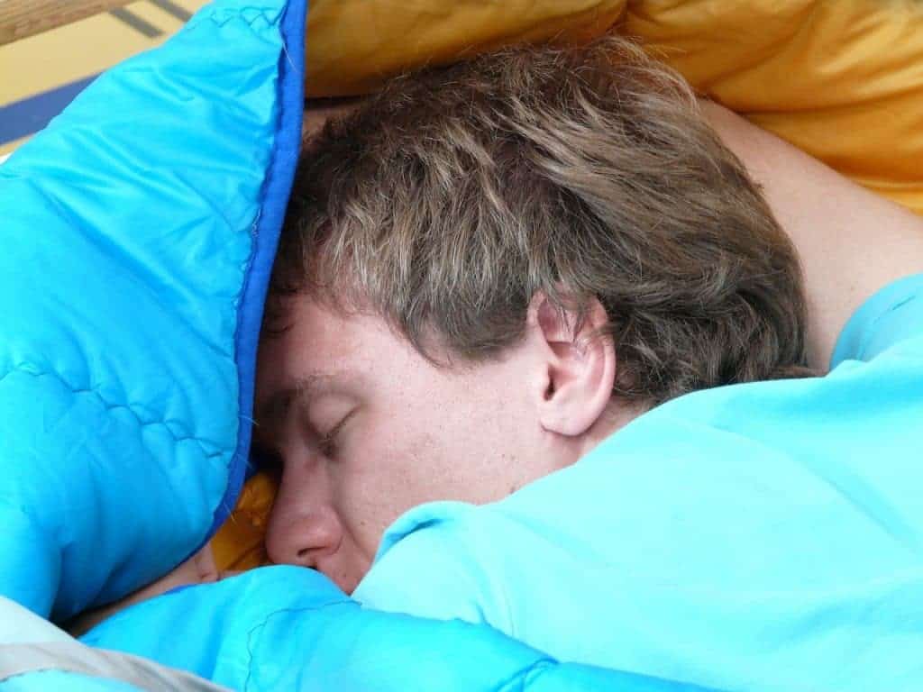 Tired man sleeping on the best sleeping bag