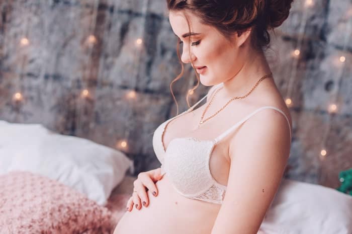 Lady Sitting on bed in Maternity Bra