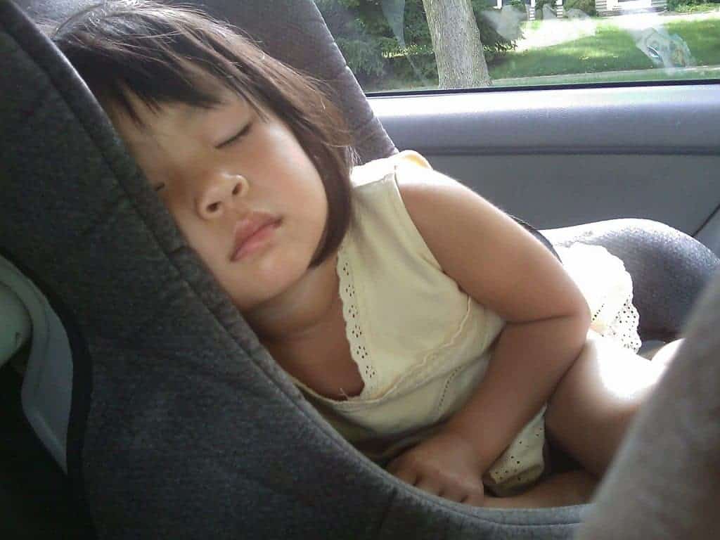 little girl sleeping inside the car