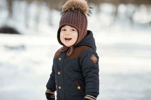 charming little boy funny winter hat poses