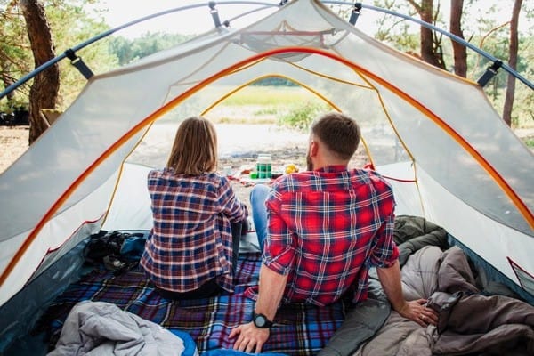 High Angle Couple Enjoying Nature View From Tent
