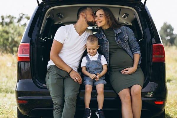 Husband With Pregnant Wife Their Son Sitting Car