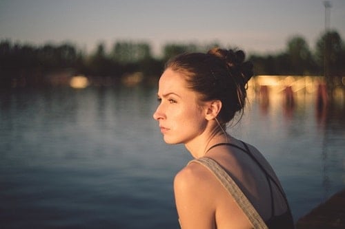 sad woman sat on waterside