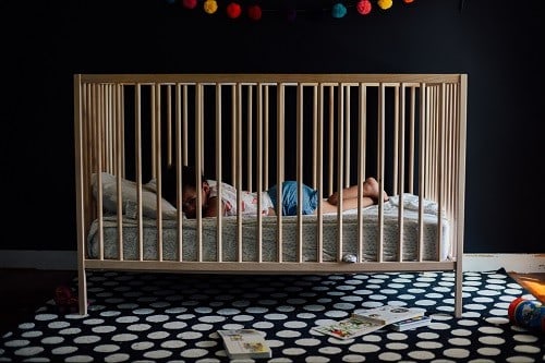 Baby inside the wooden crib