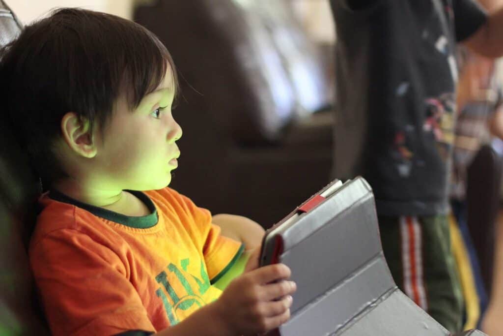 A young boy holding a tablet in his hands